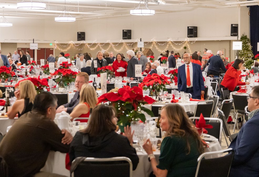 Guests seated at festive tables at the 34th annual Christmas Dinner and Auction