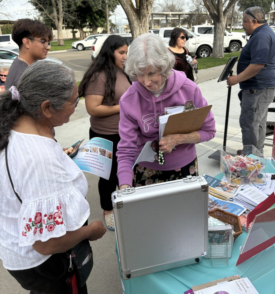 Volunteers talking with neighbors at a community outreach table