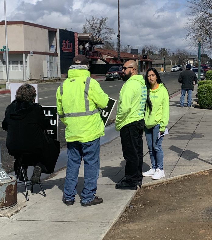 Lifehouse volunteers in bright yellow vests on the sidewalk outside Planned Parenthood